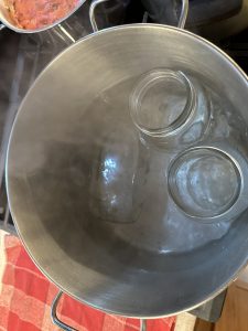 Glass jars in large pot of hot water